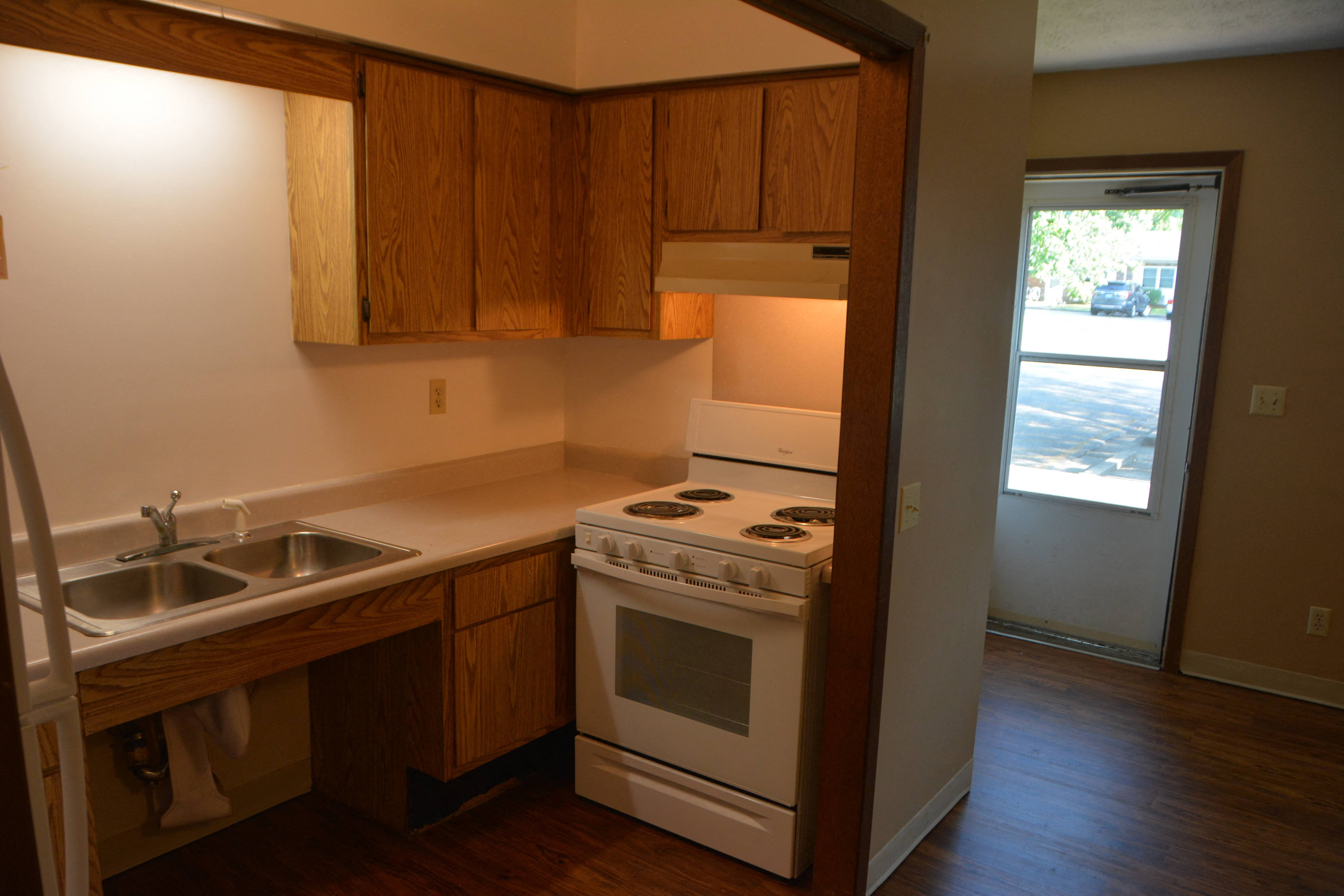 an empty kitchen with a stove and a sink